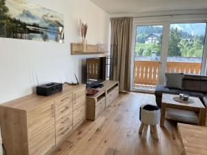a living room with a large window and a couch at Panorama Lodge Mountainview 208 in Tauplitz