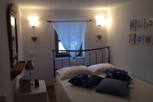 een slaapkamer met een bed met kussens en een raam bij Maisonette Zoe in Skiros