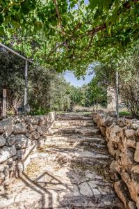 un sentiero in pietra con un muro di pietra e alberi di Mettler Winery a ‘Agur