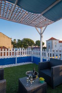 un patio con una mesa con copas de vino. en Y Quebedo - Boutique Apartments, en Setúbal