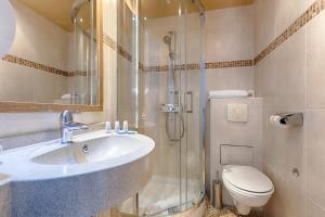 a bathroom with a shower and a sink and a toilet at Grand Hotel Dore in Paris