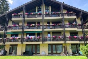 ein Apartmenthaus mit Blumen auf den Balkonen in der Unterkunft Appartement familial cosy - 2 à 6 personnes in Crans-Montana
