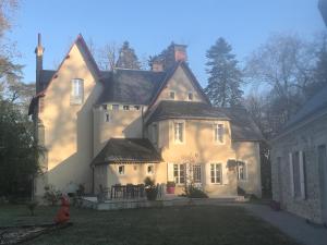 una gran casa blanca con una boca de incendios roja delante de ella en Château de la Coudraie, en Changé