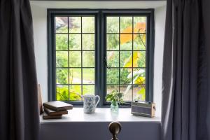 uma janela com livros e um vaso no parapeito da janela em The Bell at Sapperton em Cirencester