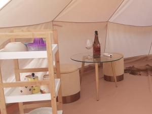 a tent with a table and a bottle of wine at The Shepherd tent on Acquaviva Bay in Marittima