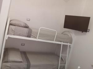 Zimmer mit einem Etagenbett und einem Flachbild-TV in der Unterkunft House Pierclaudio e Domitilla in Monte San Biagio