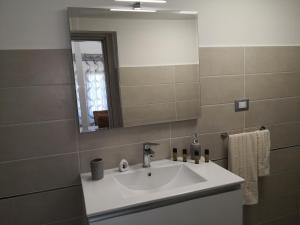 ein Bad mit einem Waschbecken und einem Spiegel in der Unterkunft House Pierclaudio e Domitilla in Monte San Biagio