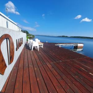 a wooden dock with two white tables on the water at Western Hills in Gdańsk