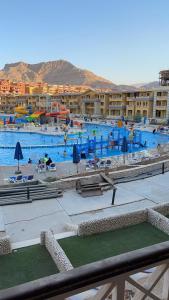 a large swimming pool in a resort with people in it at بورتو السخنه الكاربيان العاب مائيه - عائلات فقط in Ain Sokhna