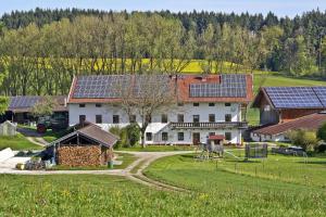 una gran casa blanca con paneles solares. en Paulhof am Chiemsee, en Seeon-Seebruck