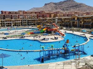 a large water park with slides and people in it at بورتو السخنه الكاربيان العاب مائيه - عائلات فقط in Ain Sokhna