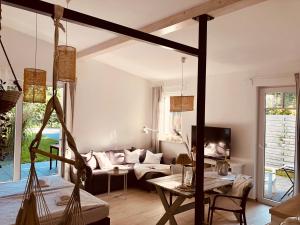 een woonkamer met een bank en een tafel bij GartenLoft mit Outdoor Whirlpool und Garten in Petershagen