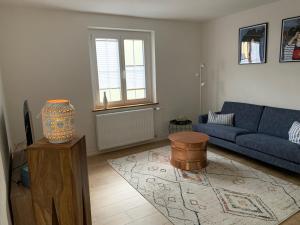 a living room with a blue couch and a table at Ferienwohnungen Bohner/Wohnung Elisabeth in Meersburg