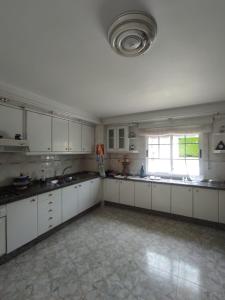 a large kitchen with white cabinets and a large window at CASA DE MELCHOR in Cruces