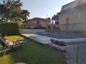 two people laying in a lawn chair next to a swimming pool at CASA DE MELCHOR in Cruces