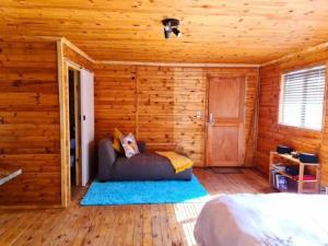 ein Schlafzimmer mit einem Bett in einer Holzhütte in der Unterkunft Hoogeland's Wood Cabins in Eersterivier