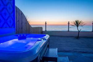 a bath tub sitting on the side of a beach at Tolcarne Beach Colonial Restaurant and Rooms in Newquay