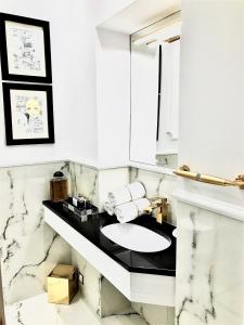 a white bathroom with a sink and a mirror at Luxury Apartments MONDRIAN Market Square III in Warsaw