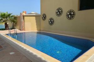 a large blue swimming pool in a house at Villa Quinta on Palm Jumeirah - 5 BR + kids room in Dubai