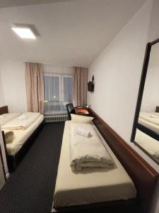 ein Hotelzimmer mit 2 Betten und einem Spiegel in der Unterkunft Brunnen Hotel in Essen