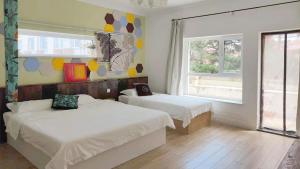 1 dormitorio con 2 camas y ventana en July Inn Weihai, en Weihai