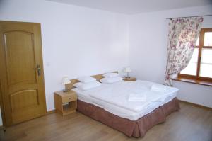 Schlafzimmer mit einem Bett mit weißer Bettwäsche und einem Fenster in der Unterkunft Giszowiec Pokoje gościnne Przyjazna 9 in Kattowitz