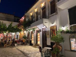 a group of people sitting at tables outside a building at Raphael Skiathos Living-Olga in Skiathos