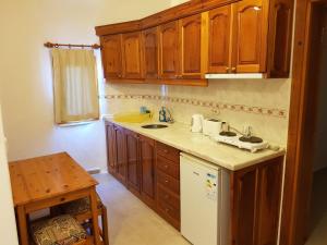 een keuken met houten kasten en een wastafel bij Dolphin Apartments in Fethiye