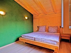 uma cama num quarto com uma parede verde em Ferienwohnung Schöpf em Kiefersfelden