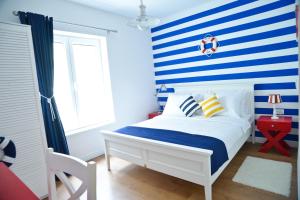 a bedroom with a blue and white striped wall at Nautical rooms Old town in Zadar