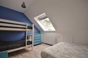 - une chambre avec un mur bleu et des lits superposés dans l'établissement Un p'tit nid au Paradis, au Crotoy