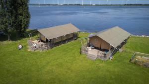 una vista aérea de dos cabañas en el césped cerca del agua en Jachthaven Nieuwboer, en Bunschoten