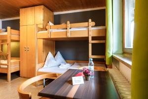 a room with a table and a bunk bed at Jugendherberge Kreuth am Tegernsee in Kreuth