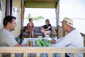 um grupo de pessoas sentadas em uma mesa em um barco em Jachthaven Nieuwboer em Bunschoten