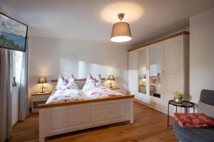 una camera da letto con un letto con cuscini rosa e bianchi di Haus Lindeneck - Erika Schwentner a Kössen