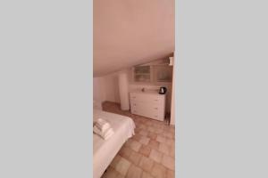 a small attic bedroom with a bed and a dresser at Via Pisa 20 Mansarda in Bari +4 photos
