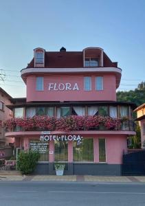 ズラトグラッドにあるFamily Hotel Floraの花の宿と書かれたピンクの建物