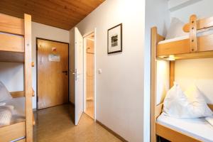 a small room with bunk beds and a hallway at Jugendherberge Kreuth am Tegernsee in Kreuth