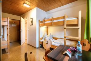 Zimmer mit Etagenbetten, einem Tisch und einem Esszimmer in der Unterkunft Jugendherberge Kreuth am Tegernsee in Kreuth