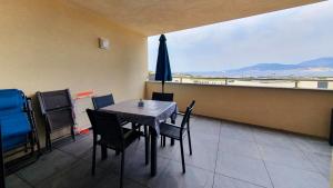 une salle à manger avec une table, des chaises et un parasol dans l'établissement LoCorse - Superbe appartement T2 avec une belle vue mer, à Grosseto-Prugna