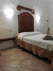 1 dormitorio con 2 camas y puerta de madera en Beni Benìus, en Teulada