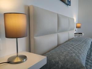 lampa siedząca na stole obok łóżka w obiekcie Torresol 402 w mieście Nerja