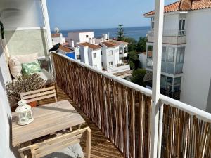 a balcony with a wooden railing and a table and chairs at Beautiful apartment in the centre of Nerja in Nerja