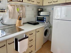 a kitchen with a white refrigerator and a washing machine at Beautiful apartment in the centre of Nerja in Nerja