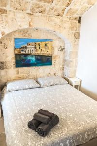 a bedroom with a bed in a stone wall at Dimore del Borgo Antico - Il Nido al mare in Monopoli