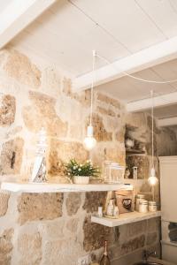 a stone wall in a kitchen with two pendant lights at Dimore del Borgo Antico - Il Nido al mare in Monopoli