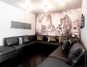 a black leather couch in a room with a mural at The Tudor House - Sleep Up To 14, City Centre, Parking & Optional Hot Tub in Chester