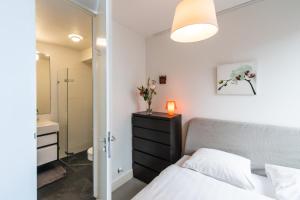 - une chambre avec un lit, une commode et un miroir dans l'établissement Tweede Laurierdwarsstraat Apartment, à Amsterdam