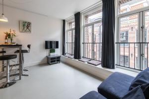 a living room with large windows and a couch at Tweede Laurierdwarsstraat Apartment in Amsterdam