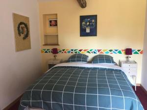 1 dormitorio con 1 cama azul y 2 mesitas de noche en Le Gîte de Las Peyros, en Mirandol-Bourgnounac